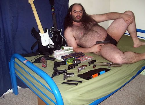 fat_hairy_guy_on_bed_with_guns-1.jpg